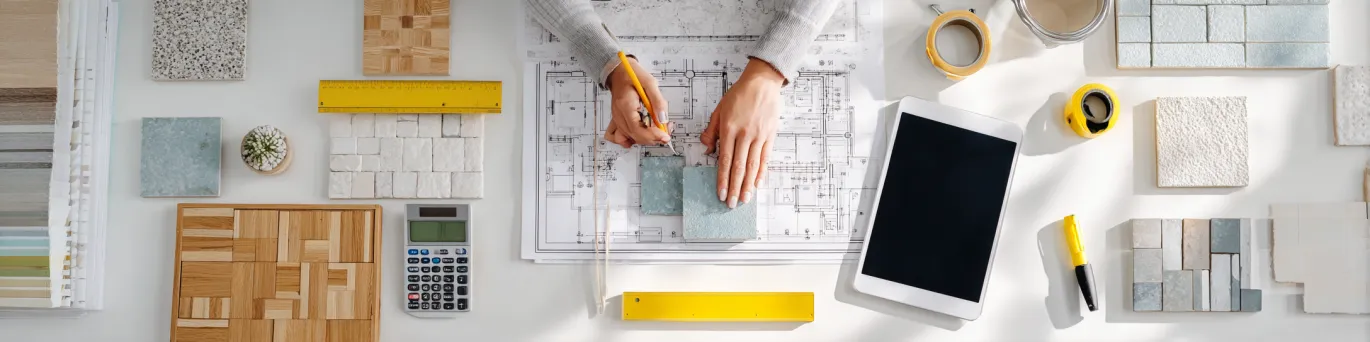 Mètre ruban professionnel déplié sur plan architectural pour mesurer surface pièce